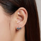Dragonfly ear studs on a model: sterling silver with blue wings, green details, and pink gem