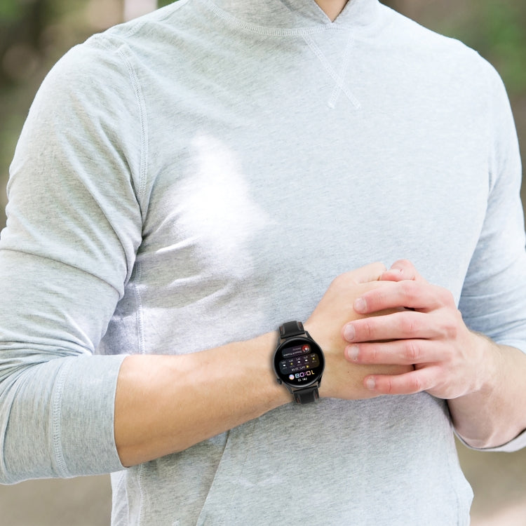 Black silicone watch strap on wrist with perforated band and metal clasp
