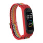 Rainbow woven watch strap with red silicone frame and metal buckle clasp for fitness tracker.