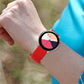 Red perforated silicone watch band worn on wrist with rose-gold buckle