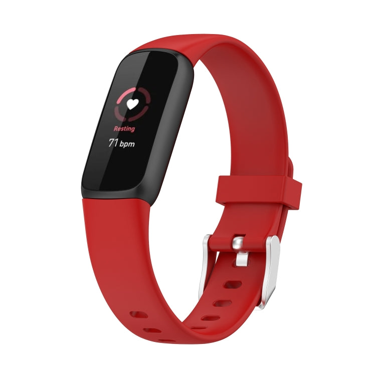 Red silicone smartwatch band with buckle and perforations; dark fitness display shown.