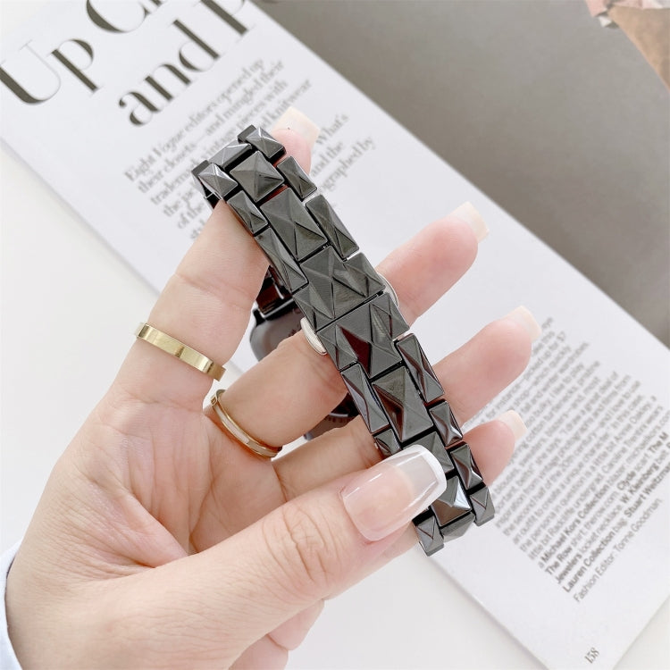 Rhombic grid ceramic watchband, black with red inlays, close-up in hand