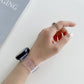 Pink translucent silicone watch strap with perforated holes and clear clasp, worn on wrist