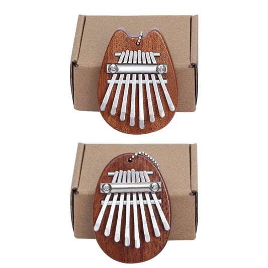 Two wood mini kalimba thumb pianos with metal tines and oval bodies in kraft boxes