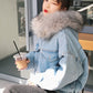 Model wearing light blue denim jacket with fluffy gray-white faux fur collar and hood.