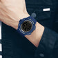 Blue digital LED sport alarm wristwatch on wrist with green luminous display and silicone band.