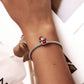 Wrist-worn bracelet with silver chain and red enamel bear charm bead
