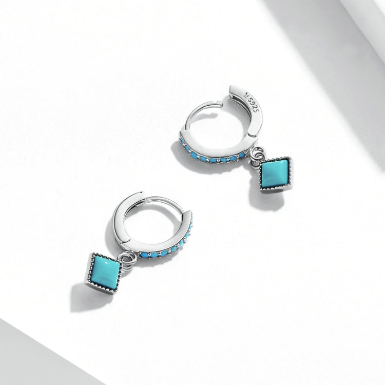 Pair of sterling silver hoop earrings with turquoise square pendants and blue side stones