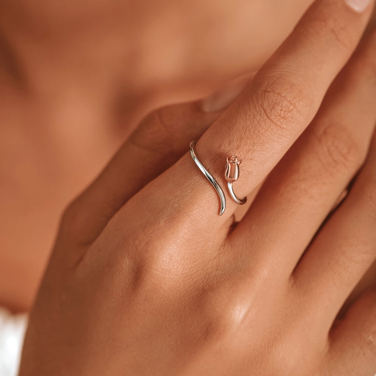 Close-up of rose open ring on finger with sterling silver band and rose-gold rose