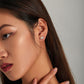 Model wearing silver sloth stud earrings with enamel face details on the ear