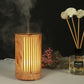Wooden essential oil humidifier with vertical slot cutouts, amber LED glow, mist vapor