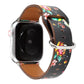 Floral watch strap with black floral print and colorful blooms, brown leather interior, metal clasp.