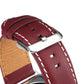 Close-up of red-brown leather watch strap buckle with stitched holes and polished metal clasp