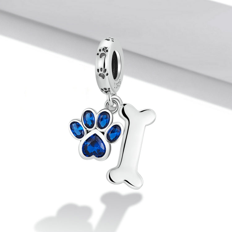 Silver dog paw and bone pendant charm with blue CZ stones, side view