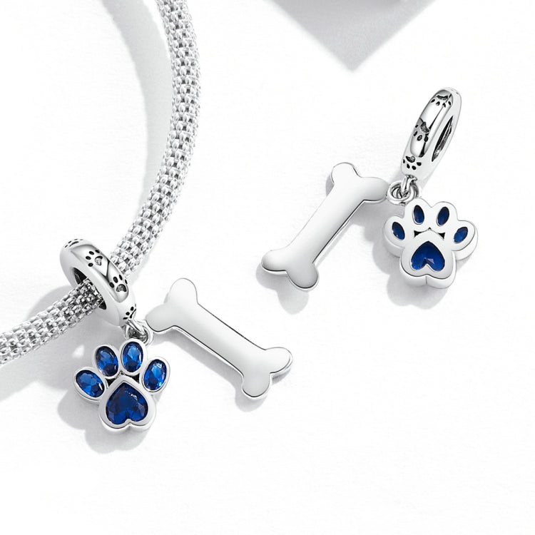 Silver charm pendant set with blue dog paw and bone on a chain bracelet