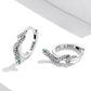 Silver snake ear buckle earrings with green eye stones, curved cuff hoop design
