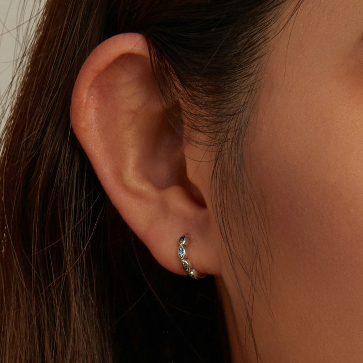 Sterling silver hoop earrings with multicolor zircon stones on a woman's ear