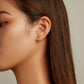 Small blue heart zircon stud earring on ear with silver backing