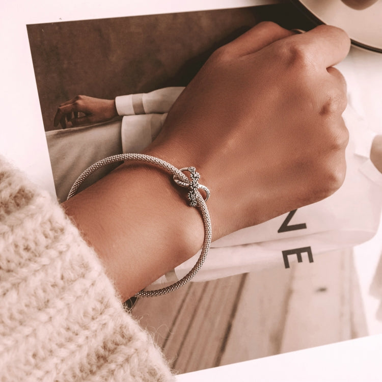 Sterling silver bracelet with infinite flower bead charm on wrist