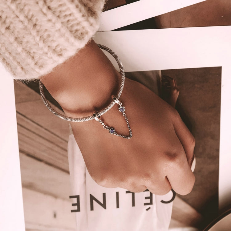 Sterling silver safety chain bracelet with purple flower charm worn on wrist