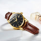 Brown leather strap wristwatch with black dial and gold-tone hands and crown