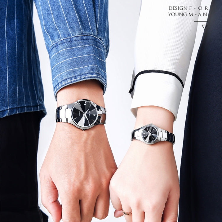 Two wrists wearing black-dial OLEVS quartz watches with silver link bracelets