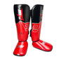 Paired red and black shin and ankle boxing leg guards with instep strap closure