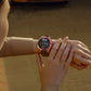Pink electroplated smartwatch case on a wrist with black strap