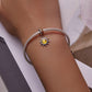 Sterling silver mesh bracelet with small sun charm featuring a yellow center