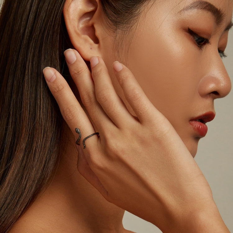 Sterling silver snake ring on a woman's finger, slim open wrap design