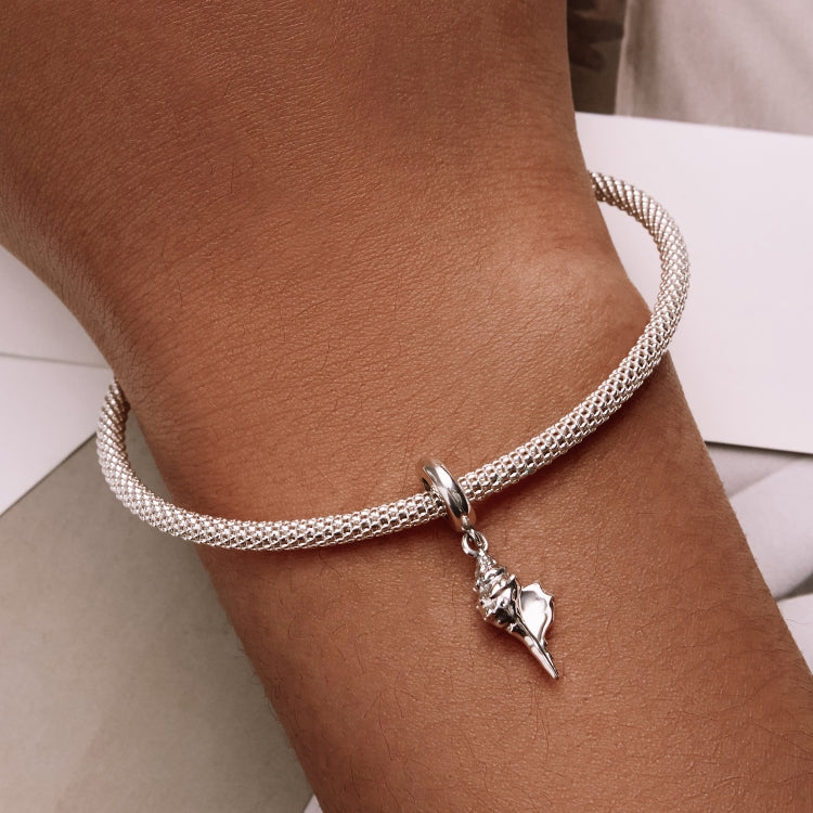 Silver conch charm bracelet on wrist with mesh chain and hanging conch pendant
