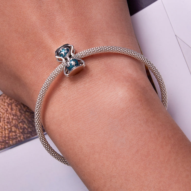 Sun and moon hourglass charm bracelet worn on wrist, silver chain with teal enamel