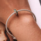 Silver mesh chain bracelet with butterfly and flower charm bead on wrist