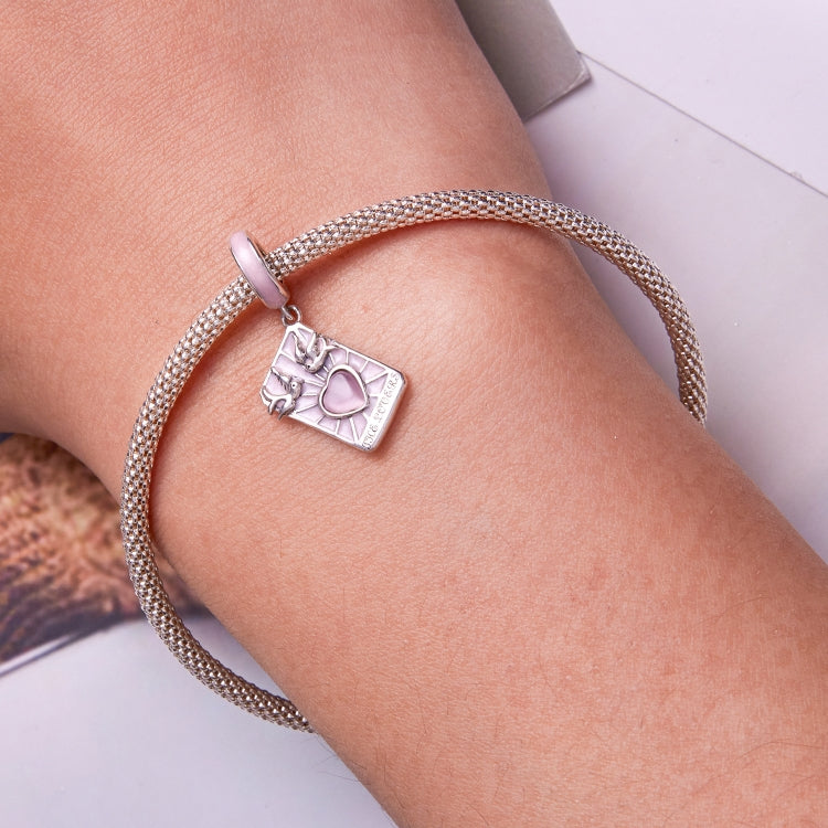 Sterling silver mesh bracelet on wrist with pink enamel tarot card charm and heart