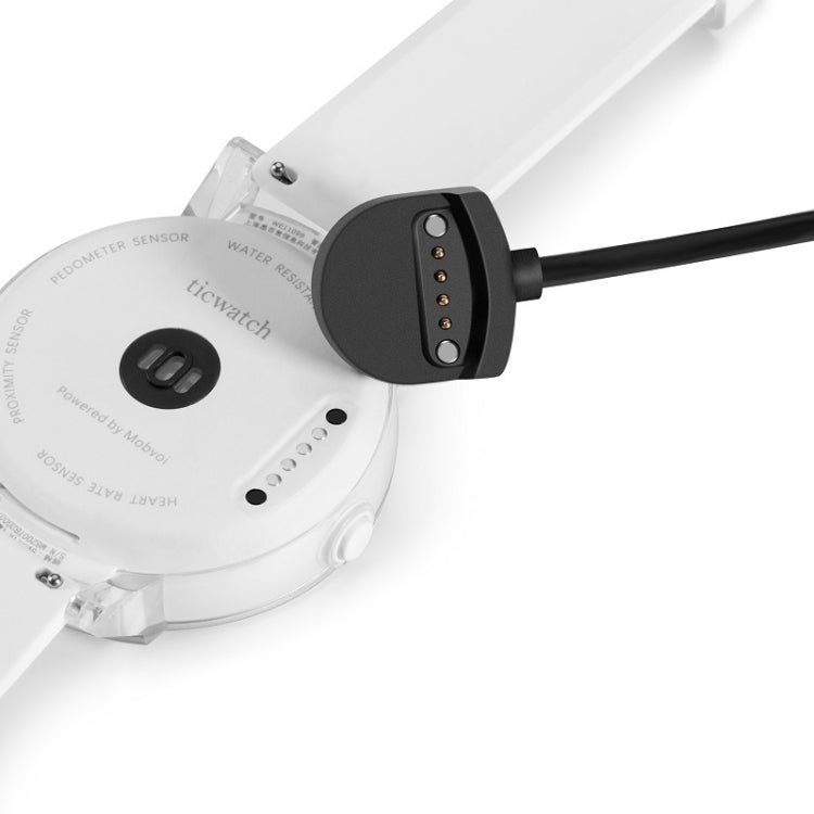 Magnetic charging dock connected to a smartwatch, showing cable pins
