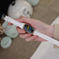 White leather slim watch band with gold buckle on wrist for Fitbit Charge 5