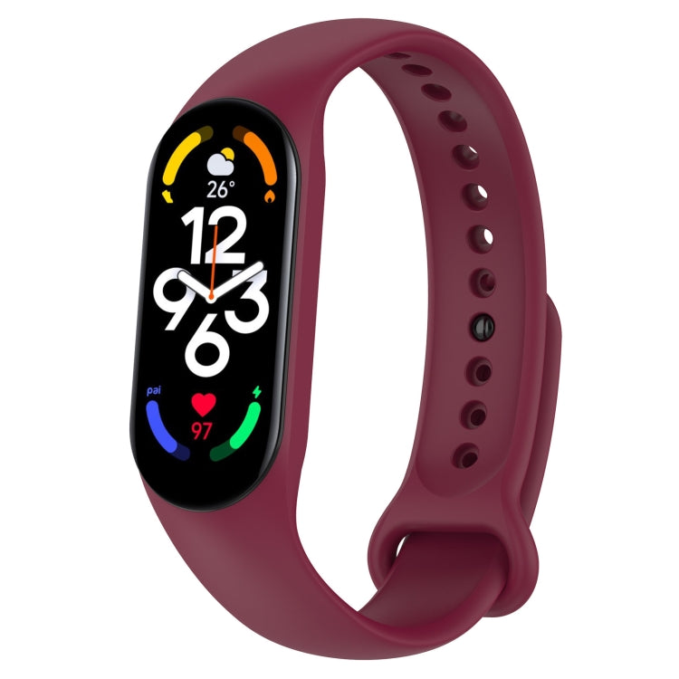 Burgundy silicone smartwatch band with perforation holes and a soft pin clasp, tracker display on.