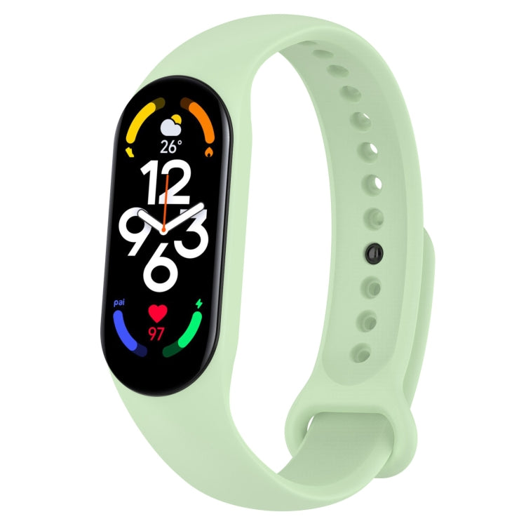 Light mint green silicone smartwatch band with perforation holes and pin clasp, tracker display on.