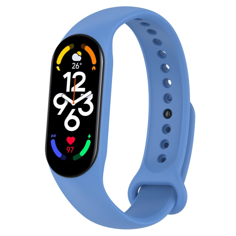 Blue silicone smartwatch band with perforation holes and pin clasp, tracker display visible.