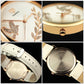 Close-up of round wristwatch: gold dove/leaf dial, crown detail, white leather strap