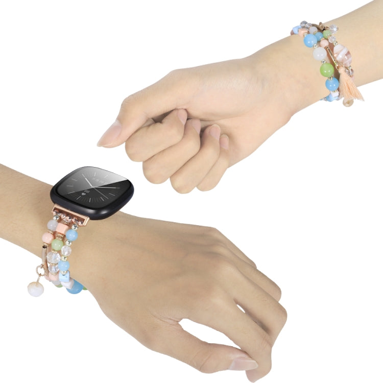 Bead chain watch band with pastel beads and crystal charms on a wrist, tassel detail