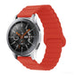 Smart watch with red silicone band and metal clasp, round black dial with orange details