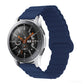 Smart watch with midnight blue silicone band and metal clasp, round black dial with orange details