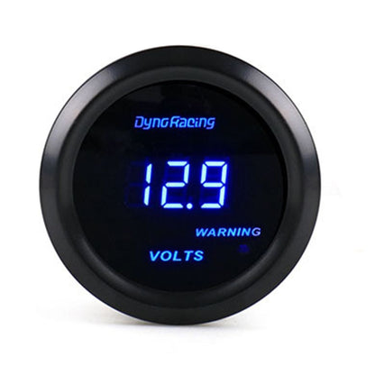 Blue digital voltmeter gauge with DynoRacing logo, black bezel; display shows 18.9