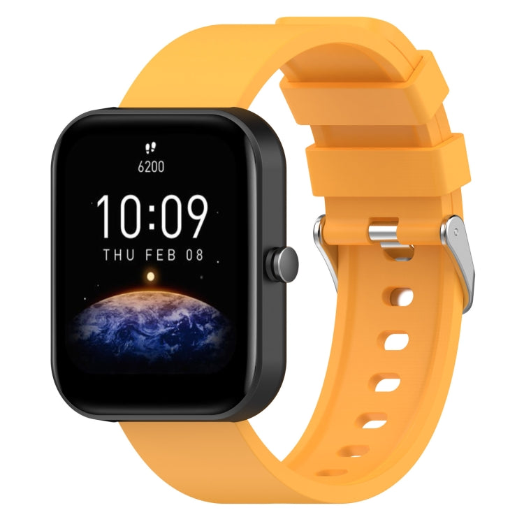 Orange silicone watch band with metal buckle and adjustment holes, shown with matching smartwatch.