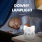 White cat-shaped wireless baby monitor on bedside table with music and power control buttons