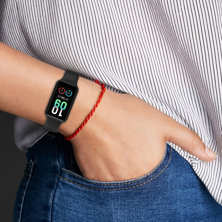 Black silicone watch band on wrist with perforated strap and smartwatch display