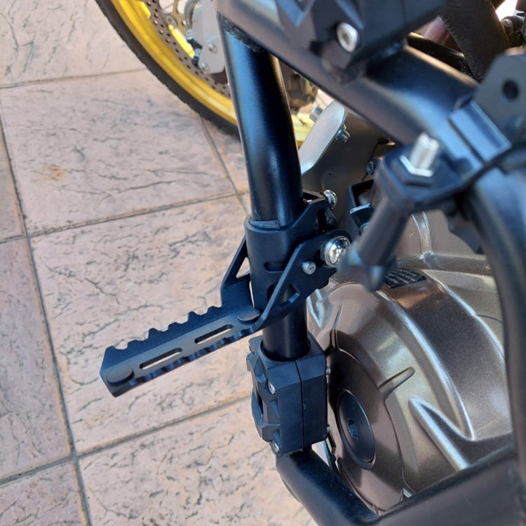 Installed black front folding foot peg and clamp on motorcycle frame
