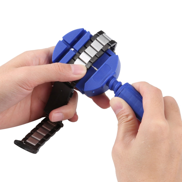 Blue and black watch band with metal clasp, held by hands for attachment