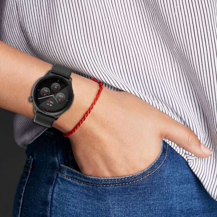 Black silicone watch band on wrist with round smartwatch face